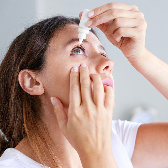 woman putting in eye drops